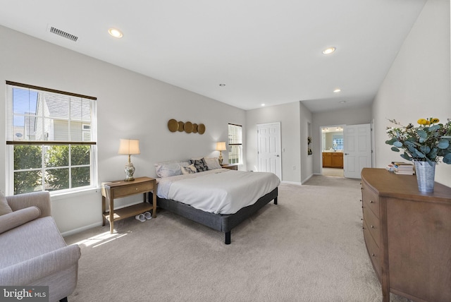 bedroom featuring ensuite bathroom, light colored carpet, visible vents, recessed lighting, and baseboards