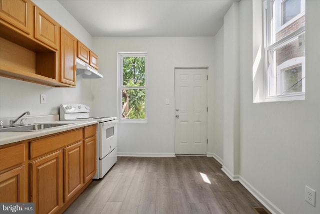 517 N 64th St, Philadelphia, PA 19151 - kitchen featuring white electric range oven, wood finished floors, under cabinet range hood, light countertops, and a sink