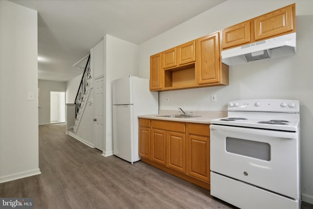 517 N 64th St, Philadelphia, PA 19151 - kitchen with white appliances, light countertops, under cabinet range hood, a sink, and wood finished floors