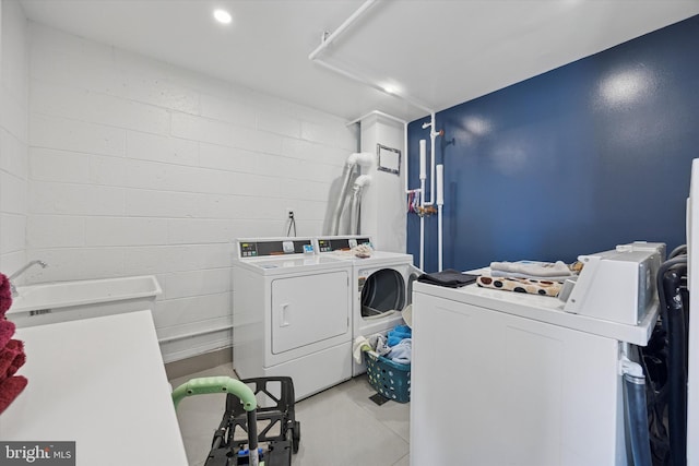 6100 Henry Ave Unit 7D, Philadelphia, PA 19128 - shared laundry room with washer and dryer, concrete block wall, and light tile patterned floors