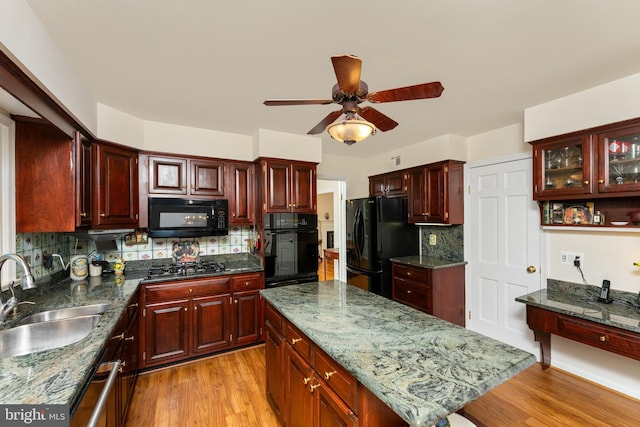 kitchen with black appliances, a sink, dark brown cabinets, a ceiling fan, and decorative backsplash