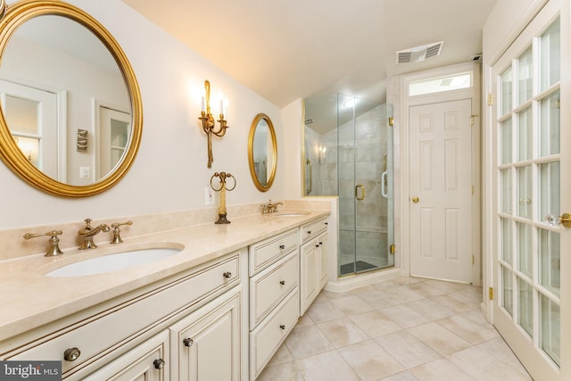 bathroom featuring tile patterned flooring, a shower stall, and double vanity