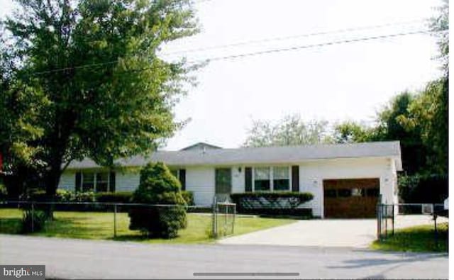 ranch-style home with an attached garage, a front lawn, and driveway