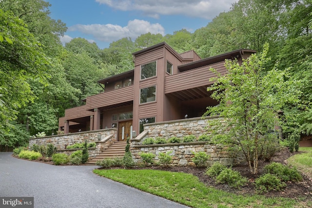 1023 Fairdell Dr, Hummelstown, PA 17036 - view of front of home featuring a balcony, stone siding, a wooded view, and stairway