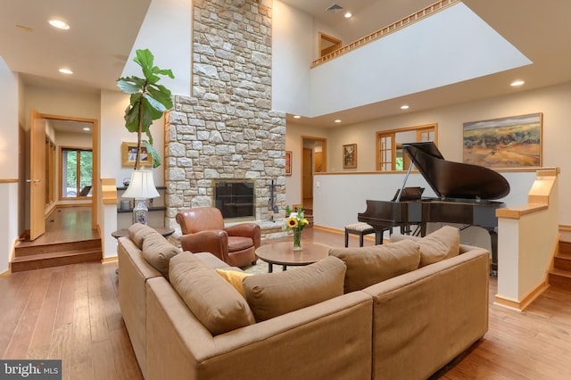 1023 Fairdell Dr, Hummelstown, PA 17036 - living area featuring hardwood / wood-style flooring, baseboards, recessed lighting, a towering ceiling, and a stone fireplace