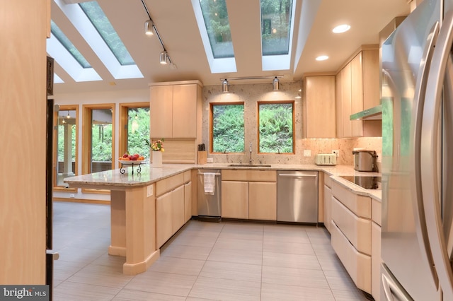 1023 Fairdell Dr, Hummelstown, PA 17036 - kitchen with appliances with stainless steel finishes, a skylight, light brown cabinets, a peninsula, and a sink