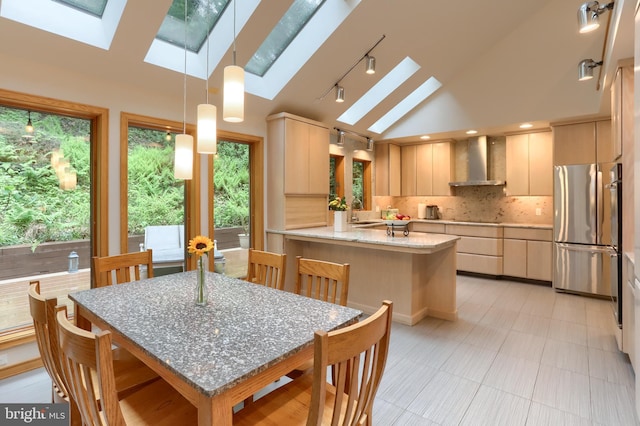 1023 Fairdell Dr, Hummelstown, PA 17036 - kitchen featuring wall chimney range hood, freestanding refrigerator, a skylight, a peninsula, and lofted ceiling