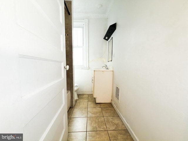 half bath with tile patterned flooring, vanity, visible vents, and toilet