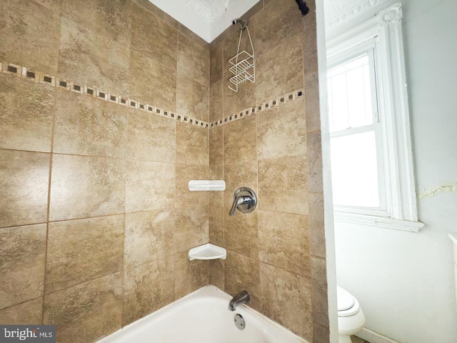 bathroom featuring toilet, shower / bathing tub combination, and a healthy amount of sunlight