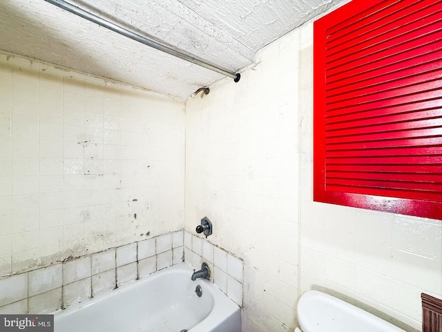 full bath with tile walls and shower / bathing tub combination