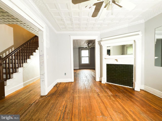 interior space featuring hardwood / wood-style floors, baseboards, a ceiling fan, and stairway