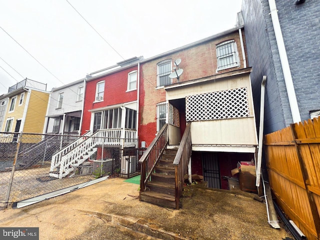 rear view of house featuring fence