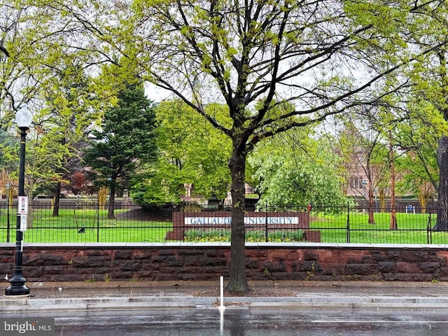 view of community featuring a yard and fence