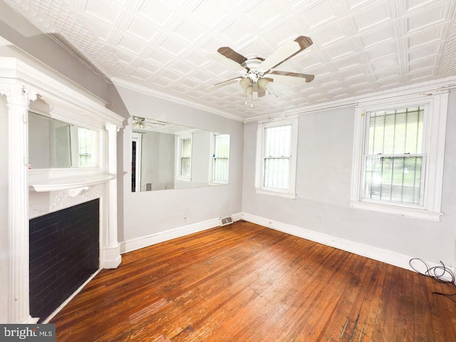 unfurnished living room with hardwood / wood-style floors, an ornate ceiling, baseboards, and a ceiling fan