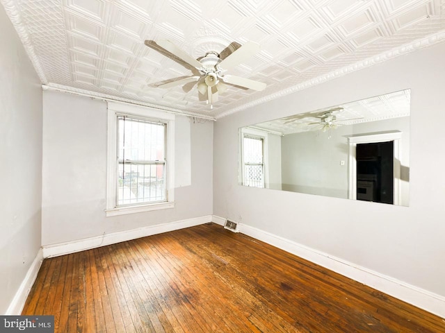unfurnished room featuring an ornate ceiling, baseboards, a ceiling fan, and hardwood / wood-style flooring