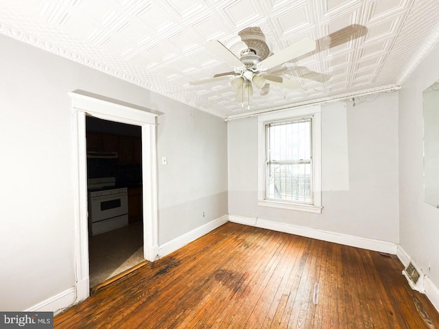 spare room featuring baseboards, a ceiling fan, visible vents, and hardwood / wood-style flooring