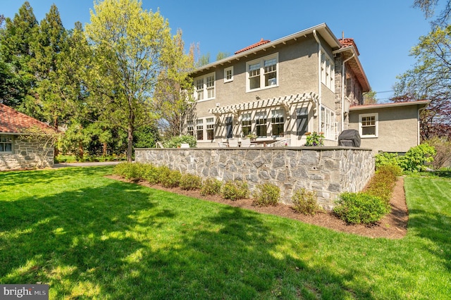 3712 Bradley Ln, Chevy Chase, MD 20815 - rear view of property featuring stucco siding, a chimney, and a yard