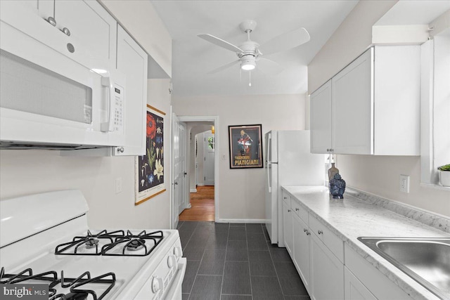 3721 Massachusetts Ave NW, Washington, DC 20016 - kitchen with white appliances, white cabinetry, ceiling fan, and light countertops