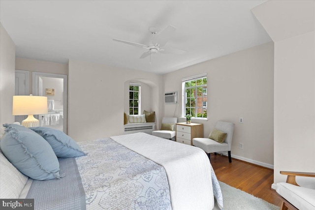 3721 Massachusetts Ave NW, Washington, DC 20016 - bedroom with wood finished floors, a wall mounted air conditioner, baseboards, and a ceiling fan