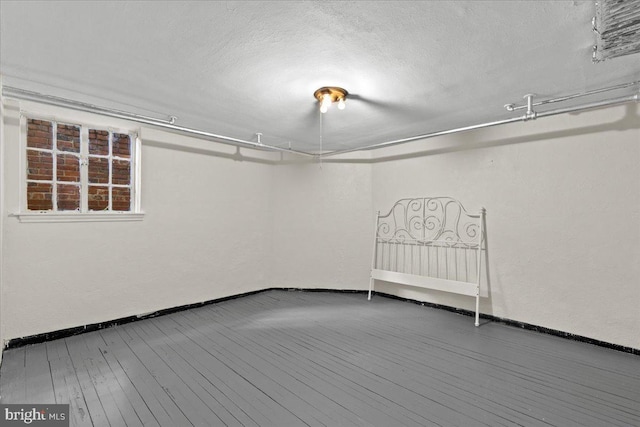 3721 Massachusetts Ave NW, Washington, DC 20016 - below grade area featuring wood-type flooring, baseboards, and a textured ceiling