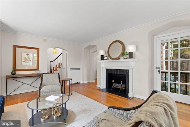 3721 Massachusetts Ave NW, Washington, DC 20016 - living room featuring radiator heating unit, stairs, wood finished floors, crown molding, and a tile fireplace
