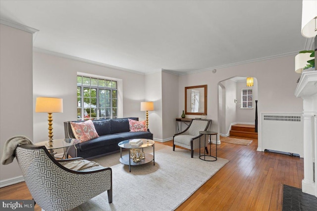 3721 Massachusetts Ave NW, Washington, DC 20016 - living area featuring radiator heating unit, arched walkways, hardwood / wood-style flooring, crown molding, and baseboards