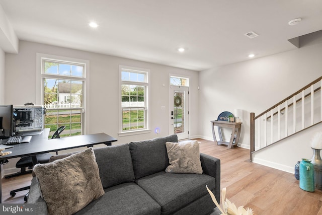 living area with baseboards, recessed lighting, stairway, visible vents, and light wood finished floors