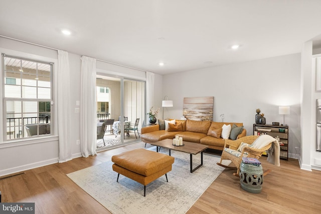 living room with visible vents, baseboards, light wood-type flooring, and recessed lighting