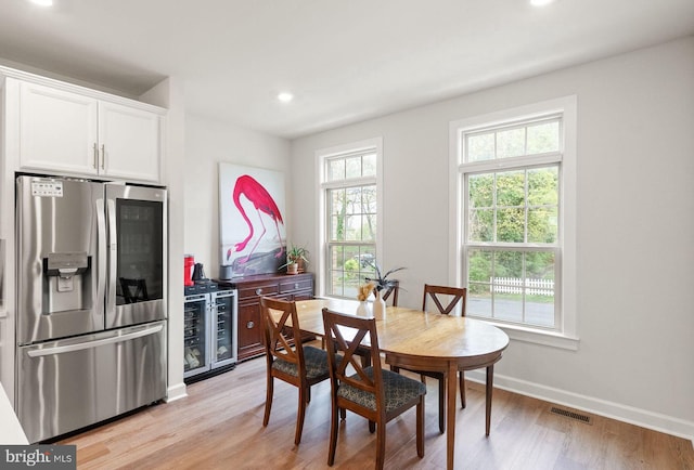 dining room with light wood-style floors, visible vents, recessed lighting, beverage cooler, and baseboards