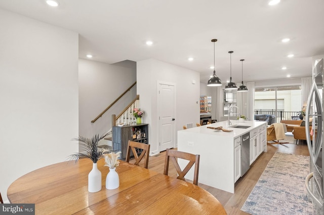 kitchen with an island with sink, white cabinetry, recessed lighting, appliances with stainless steel finishes, and a sink