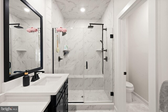full bathroom featuring vanity, baseboards, toilet, a marble finish shower, and marble finish floor