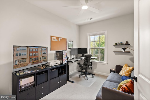 office area with visible vents, baseboards, a ceiling fan, and light colored carpet