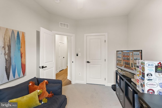 living area with visible vents, baseboards, and carpet flooring