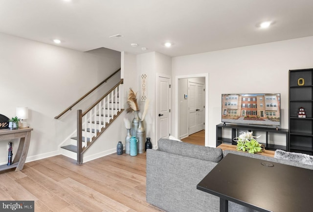 living room featuring baseboards, recessed lighting, wood finished floors, and stairs