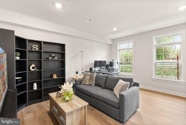 living area featuring light wood finished floors, baseboards, visible vents, and recessed lighting