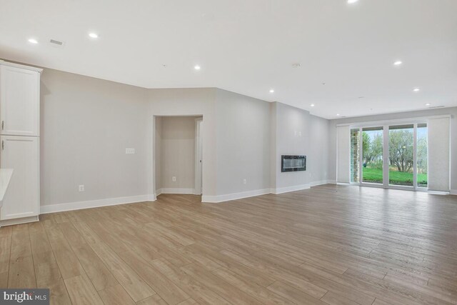 170 Harrier Way Unit 11, Chester, MD 21619 - unfurnished living room with light wood-type flooring, recessed lighting, visible vents, and heating unit