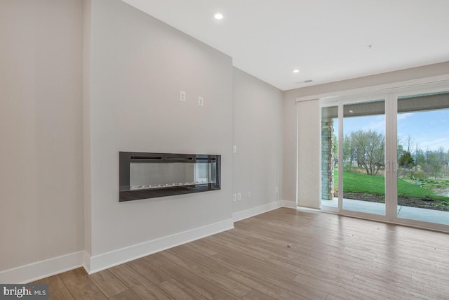 170 Harrier Way Unit 11, Chester, MD 21619 - unfurnished living room with baseboards, recessed lighting, a glass covered fireplace, and wood finished floors