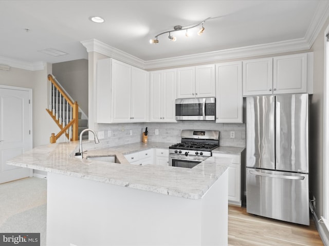 1909 Kenwood Ave Unit 303, Alexandria, VA 22302 - kitchen featuring a peninsula, ornamental molding, appliances with stainless steel finishes, a sink, and backsplash