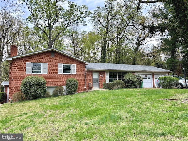 tri-level home with brick siding, a front lawn, a chimney, and an attached garage