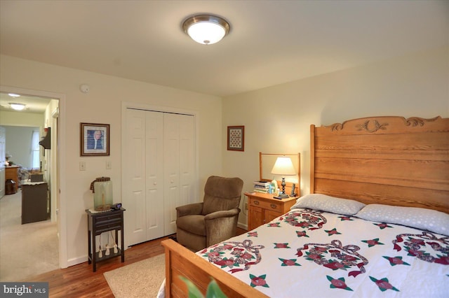bedroom featuring a closet, baseboards, and wood finished floors