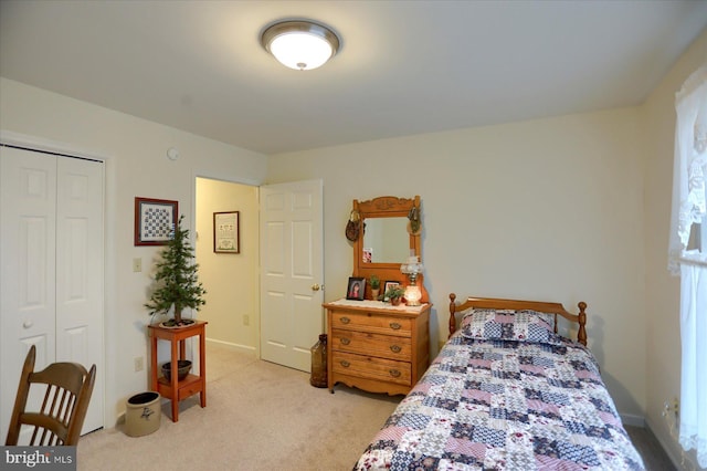 bedroom featuring light carpet, a closet, and baseboards
