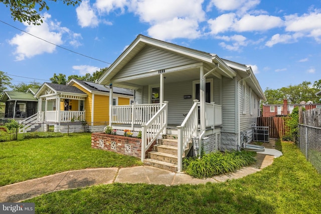 bungalow-style house featuring fence, a front lawn, and covered porch