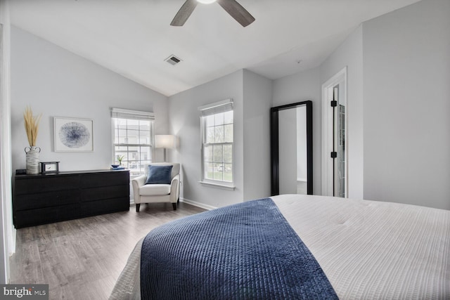 bedroom featuring visible vents, baseboards, a ceiling fan, wood finished floors, and lofted ceiling