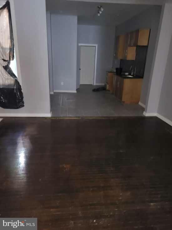 2321 W Lehigh Ave, Philadelphia, PA 19132 - unfurnished living room featuring baseboards and wood finished floors