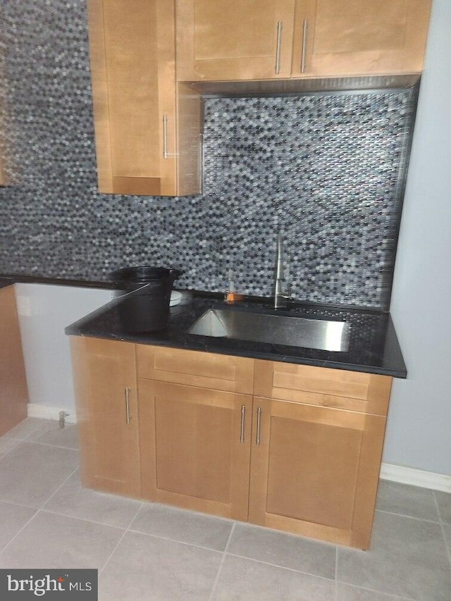 2321 W Lehigh Ave, Philadelphia, PA 19132 - kitchen featuring a sink, decorative backsplash, light tile patterned floors, and baseboards