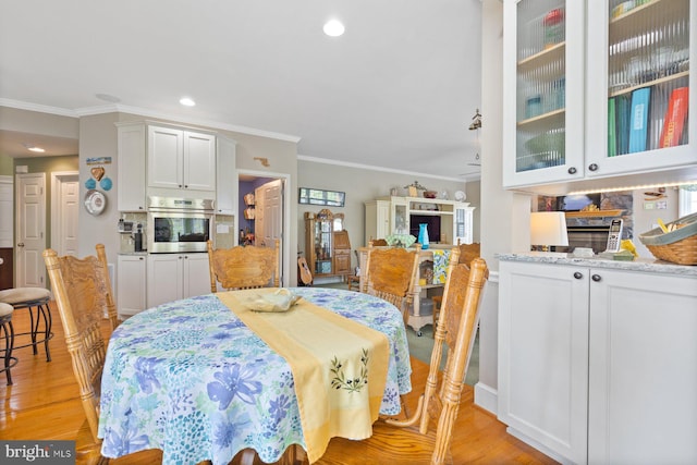 dining space with recessed lighting, ornamental molding, and light wood-style flooring