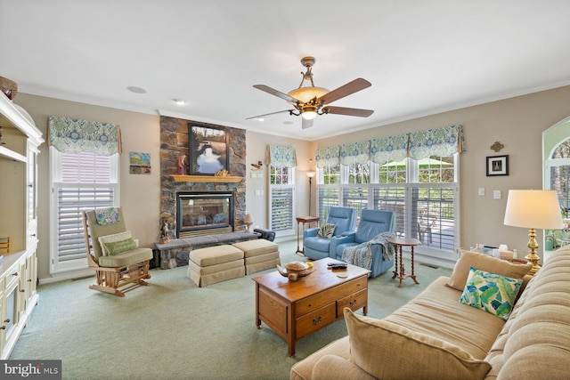 living room with a fireplace, carpet, a ceiling fan, and ornamental molding
