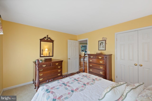 carpeted bedroom featuring a closet and baseboards