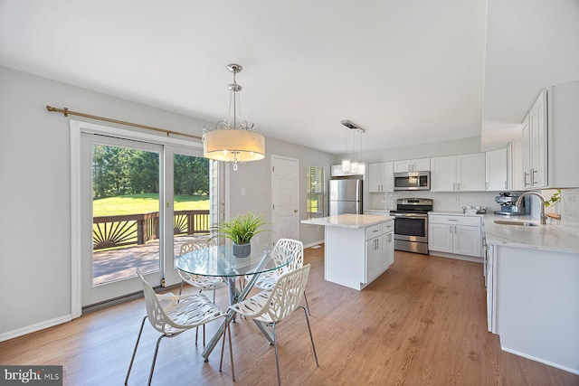 dining area with baseboards, light wood-style floors, and a healthy amount of sunlight