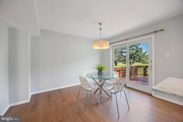 dining area with baseboards and wood finished floors